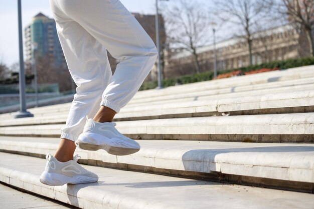 Piernas femeninas en las escaleras Rutina corriendo en el parque Foto de alta calidad