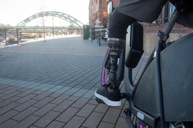 Piernas de hombre con discapacidad en bicicleta en la ciudad