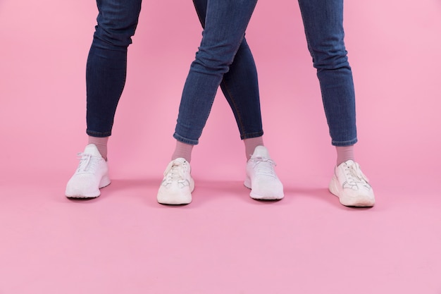 Piernas de hombre y mujer en jeans y zapatillas de deporte.