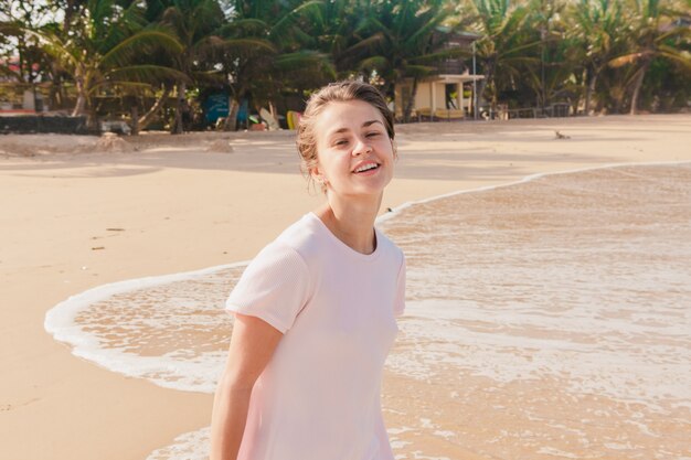 Piernas de mujer caminando por la arena de la playa