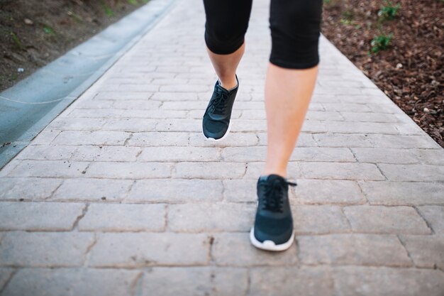 Piernas de mujer corriendo sobre el pavimento