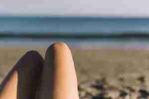 Foto gratuita piernas de mujer en la playa