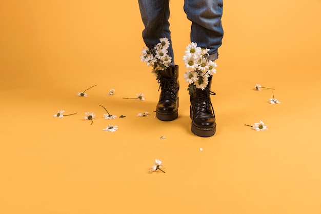 Piernas de mujer usando zapatos con flores adentro