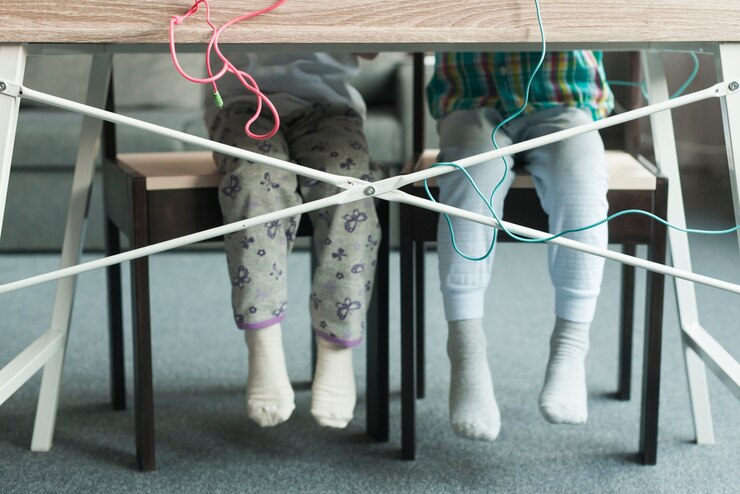 Foto gratuito piernas de niños sentados en mesa