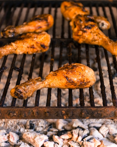 Piernas de pollo a la parrilla brillante en parrilla caliente