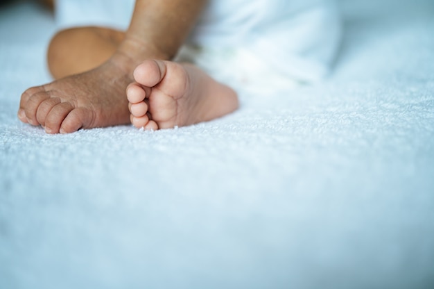 Foto gratuita pies de bebé recién nacido sobre una manta blanca