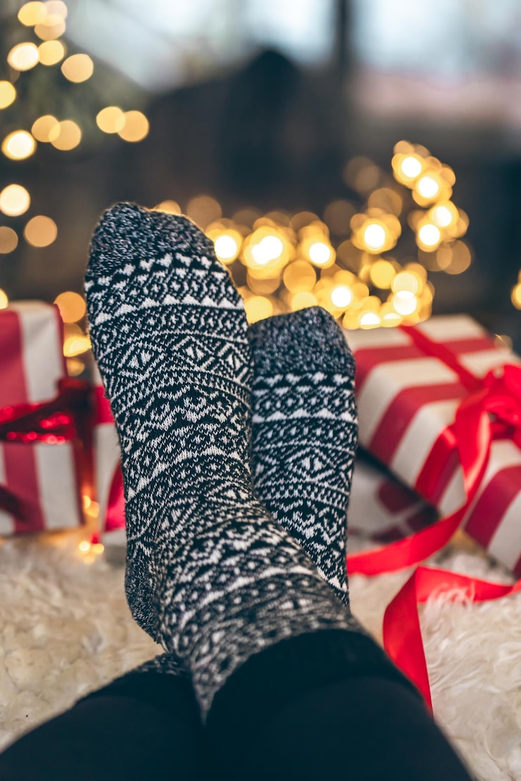 Foto gratuito pies en calcetines de navidad y cajas de regalos frente a la chimenea de cerca