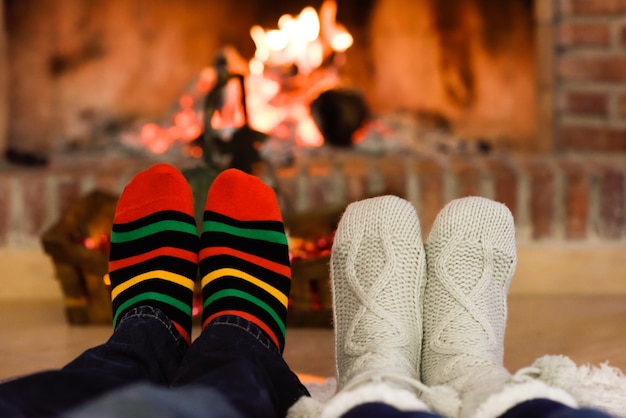 Pies con calcetines de navidad cerca de una chimenea