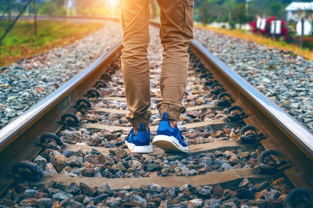 Pies de hombre caminando sobre ferrocarril. Concepto de viaje.