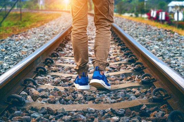 Pies de hombre caminando sobre ferrocarril. Concepto de viaje.