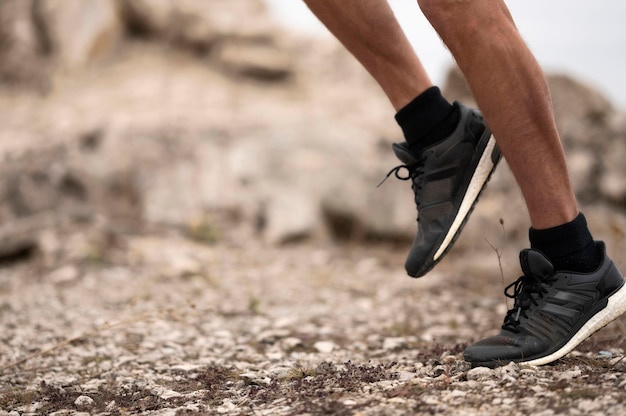 Pies del hombre de primer plano en sendero en la naturaleza