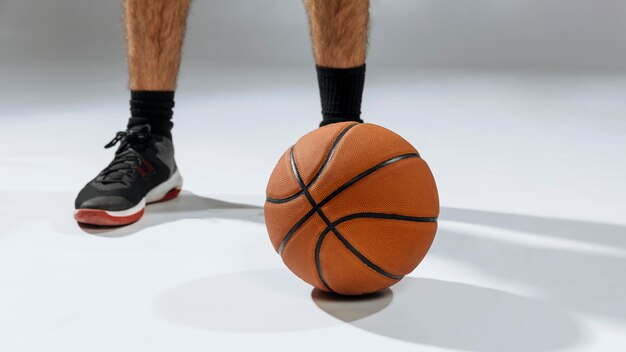 Los pies del joven jugando baloncesto
