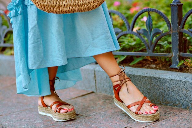 Pies de mujer en elegantes sandalias de gladiador