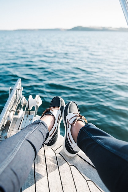 Pies de la persona en el barco navegando por el mar durante el día