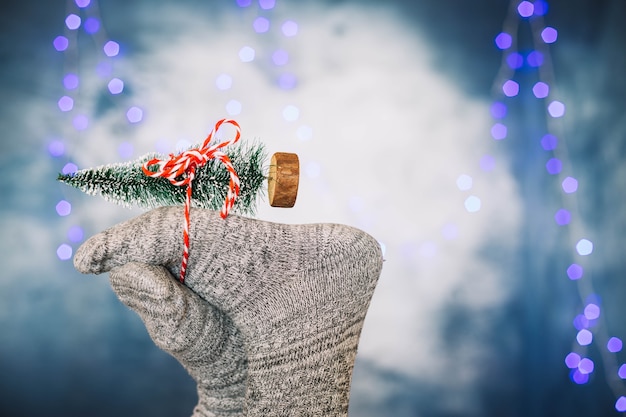 Pies sujetando árbol de navidad de juguete