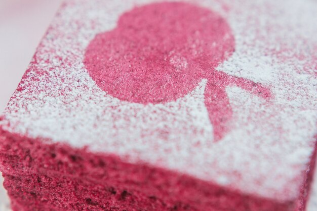 Pieza de pastila roja cubierta con azúcar en polvo superior macro vista