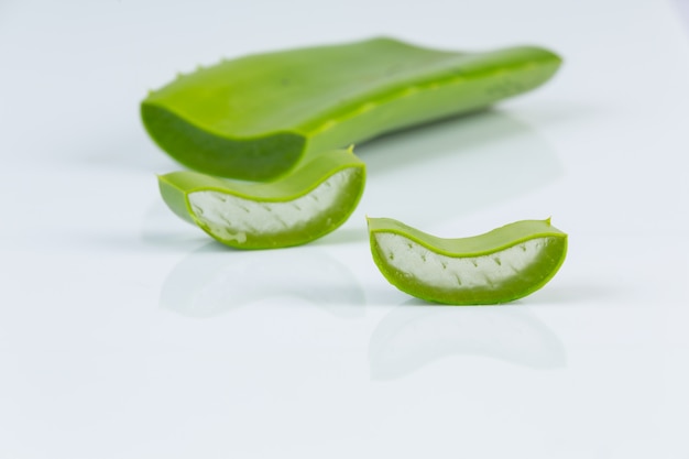 Piezas de aloe vera en la pared blanca.