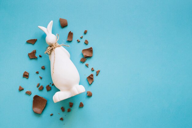 Piezas de chocolate alrededor de la estatuilla del conejito