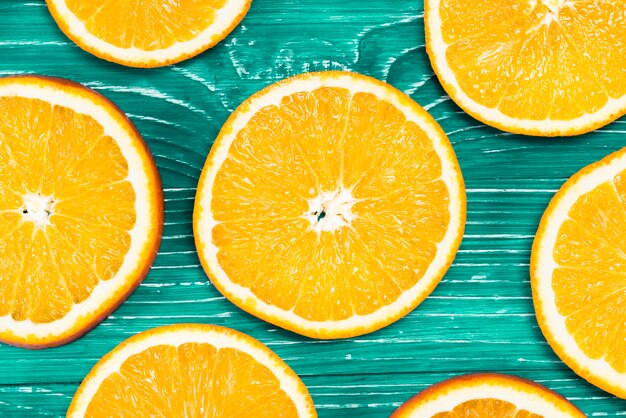 Foto gratuita piezas coloridas de naranjas en fondo verde