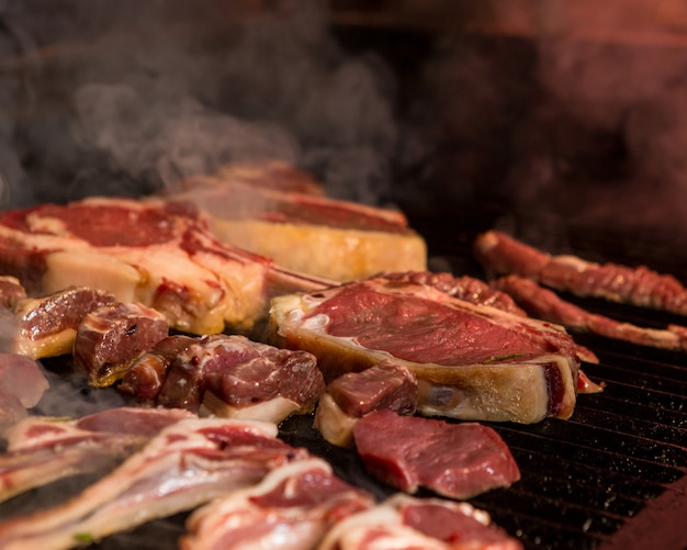 Las piezas de cordero finamente cortadas se cocinan en una parrilla de hierro