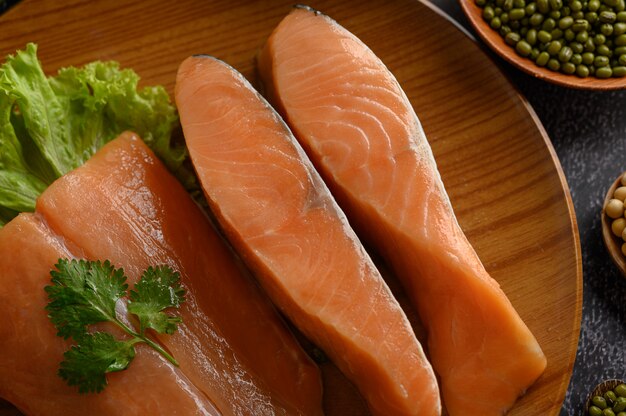 Piezas de salmón en un plato de madera. enfoque selectivo