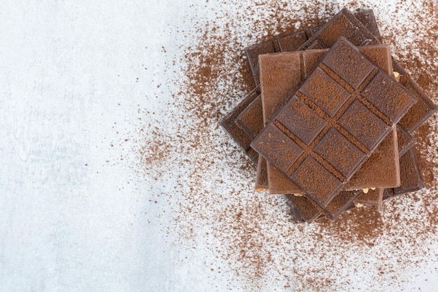 Foto gratuita pila de barras de chocolate decoradas con cacao en polvo. foto de alta calidad