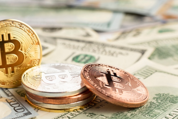 Pila de Bitcoin encima de billetes dolar