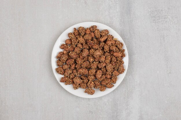 Pila de caramelos con semillas de sésamo en un plato blanco.