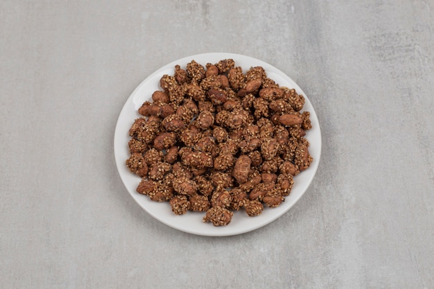 Pila de caramelos con semillas de sésamo en un plato blanco.