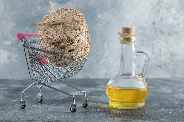 Pila de delicioso pan crujiente en un pequeño carrito con aceite de oliva