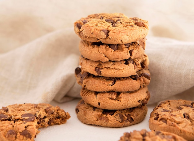 Pila de galletas con chispas de chocolate delante de tela