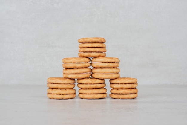 Foto gratuita pila de galletas con crema de mesa blanca.