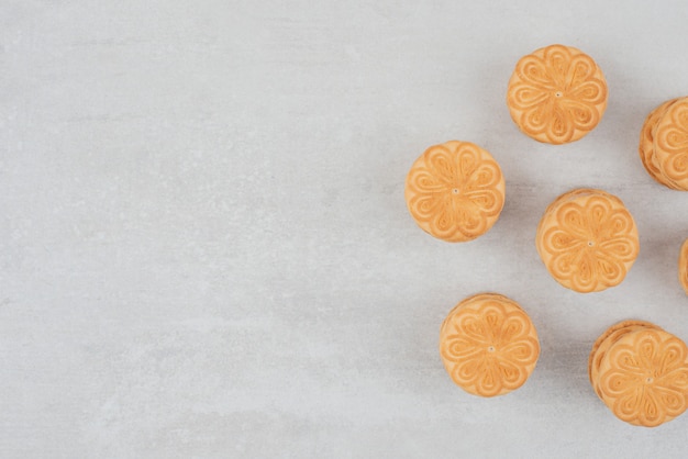 Pila de galletas con crema sobre fondo blanco.