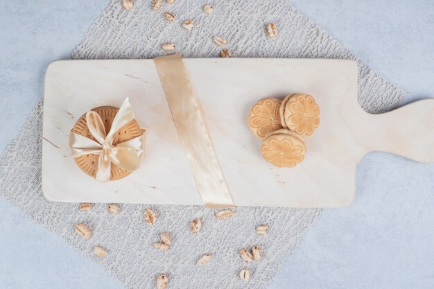 Pila de galletas festivas y cacahuetes sobre tabla de madera. Foto de alta calidad