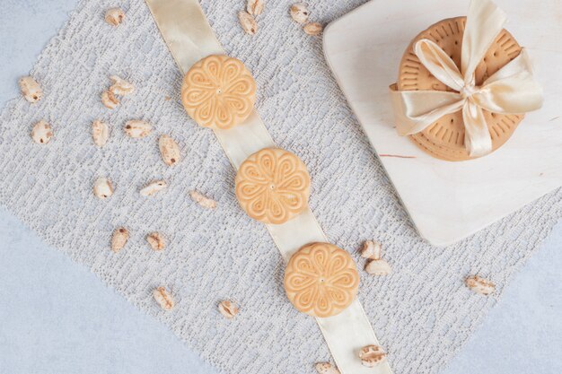 Pila de galletas festivas y cacahuetes sobre tabla de madera. Foto de alta calidad