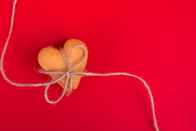 Pila de galletas en forma de corazón en la mesa roja