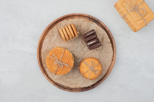 Pila de galletas de Navidad atadas con una cuerda en la placa de madera