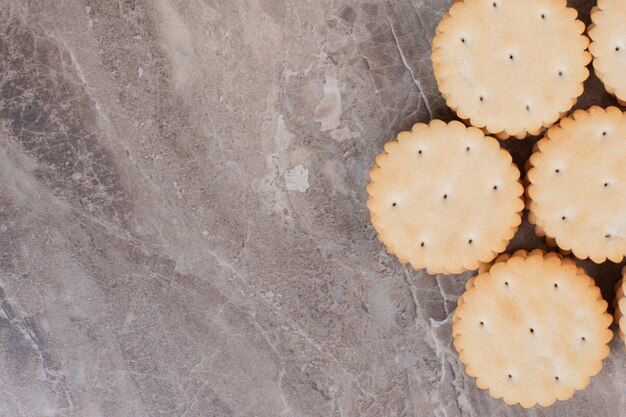 Pila de galletas redondas sobre superficie de mármol.