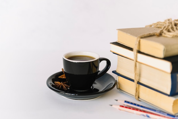 Pila de libros al lado de taza de café