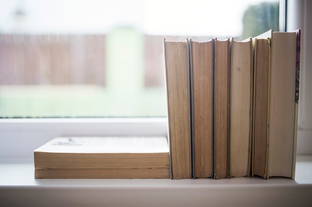 Pila de libros en el alféizar de la ventana