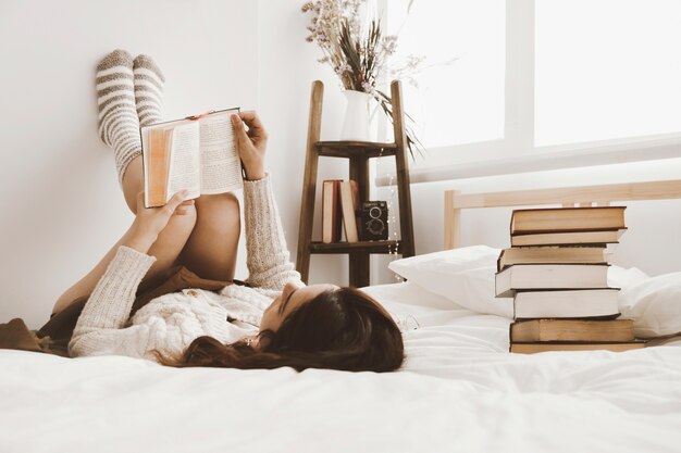 Pila de libros cerca de la lectura femenina