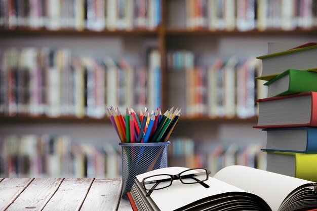 Pila de libros con gafas en escritorio de madera