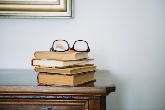 Pila de libros y gafas en el gabinete