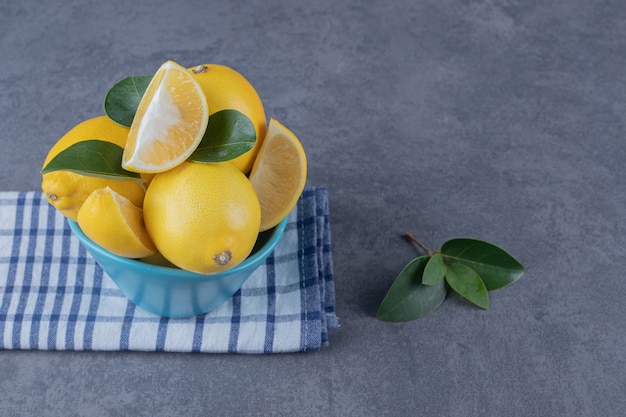 Pila de limones frescos en un tazón azul.