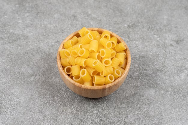 Pila de macarrones crudos en un tazón de madera