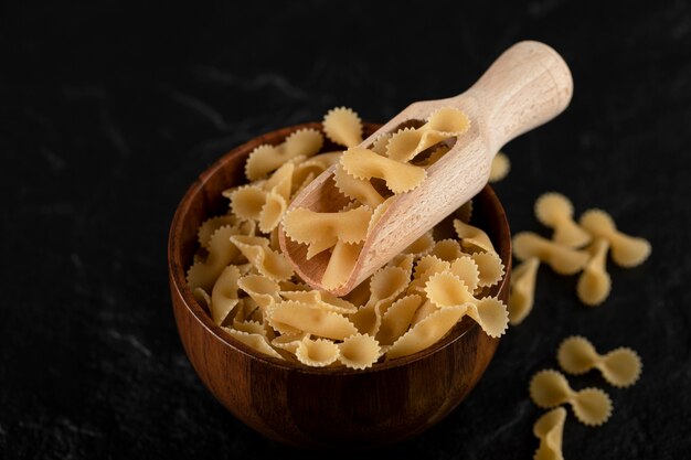 Foto gratuita pila de macarrones crudos en un tazón de madera.