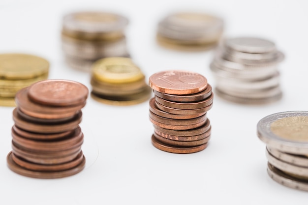 Pila de monedas de cobre con oro y plata sobre fondo blanco