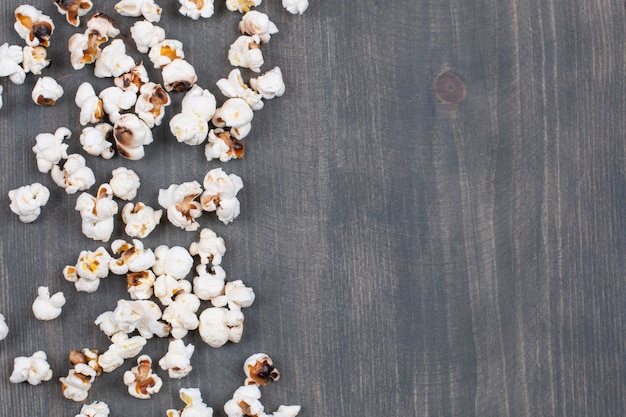 Pila de palomitas de maíz saladas sobre superficie de madera