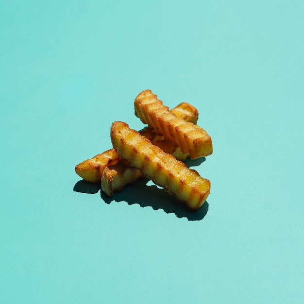 Foto gratuita pila de papas fritas en el fondo de color