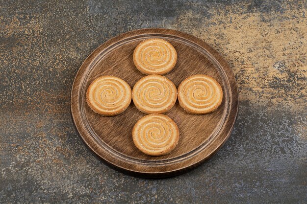 Pila de sabrosas galletas en placa de madera.